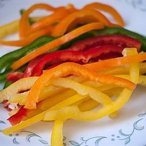 Wash and cut green, red, yellow bell peppers