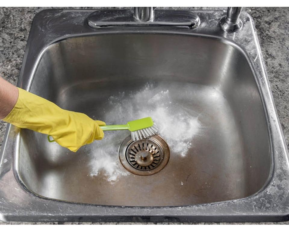 Rinse the sink with hot water once to soften the plaque